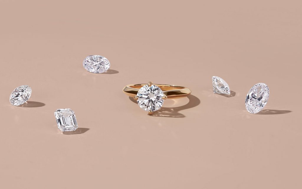 Yellow gold engagement ring with loose diamonds around it.